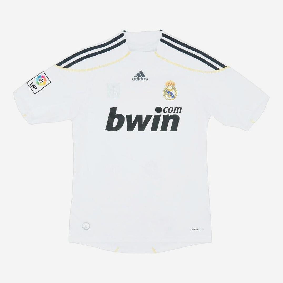 The Real Madrid 2009-10 Home Shirt by Retro1999 features black shoulder stripes, bwin.com sponsor, Adidas logo, club crest, and LFP patch—ideal for La Liga fans. Displayed on a plain white background.
