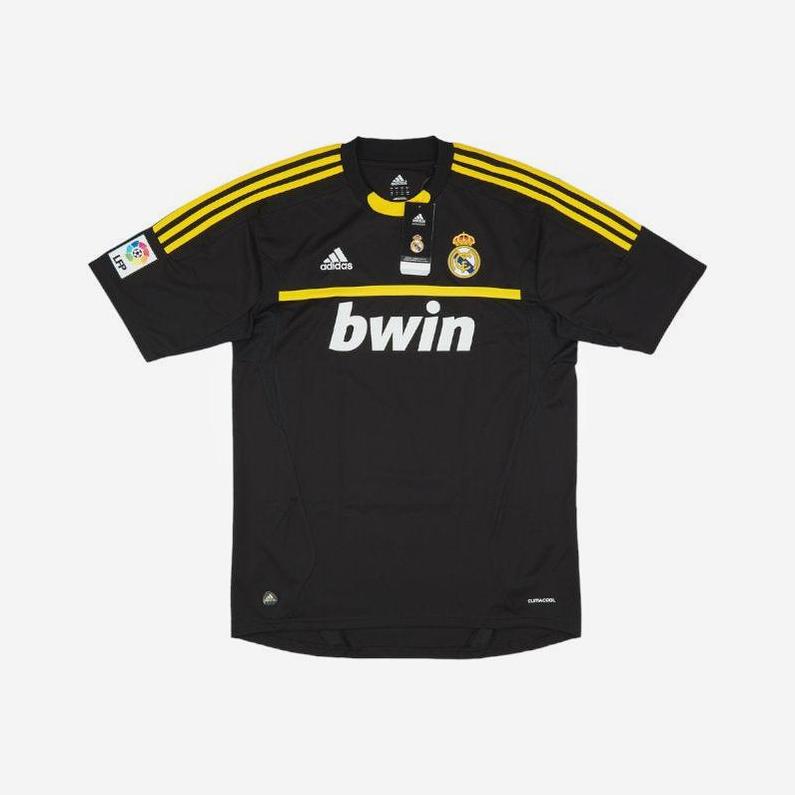 A black Retro1999 Real Madrid 2011-12 Goalkeeper Shirt with yellow accents, bwin and Adidas logos, club crest, and La Liga sleeve patch, styled like the José Mourinho era, shown on a white background.