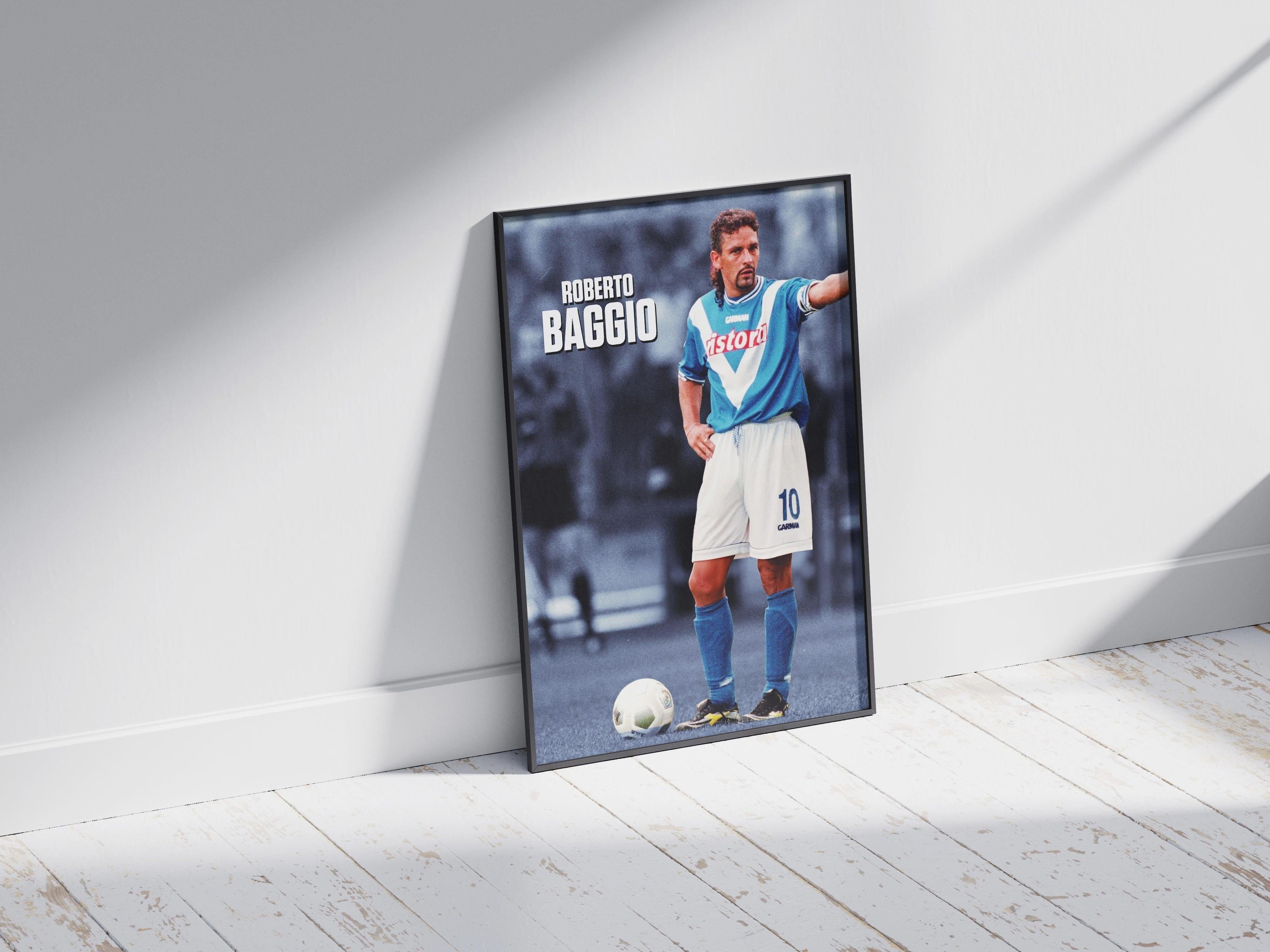 The Retro1999 Roberto Baggio x Brescia Poster, featuring the football legend in his iconic blue and white kit, is stylishly framed and placed on a white wooden floor, leaning against a light gray wall in bright natural light.