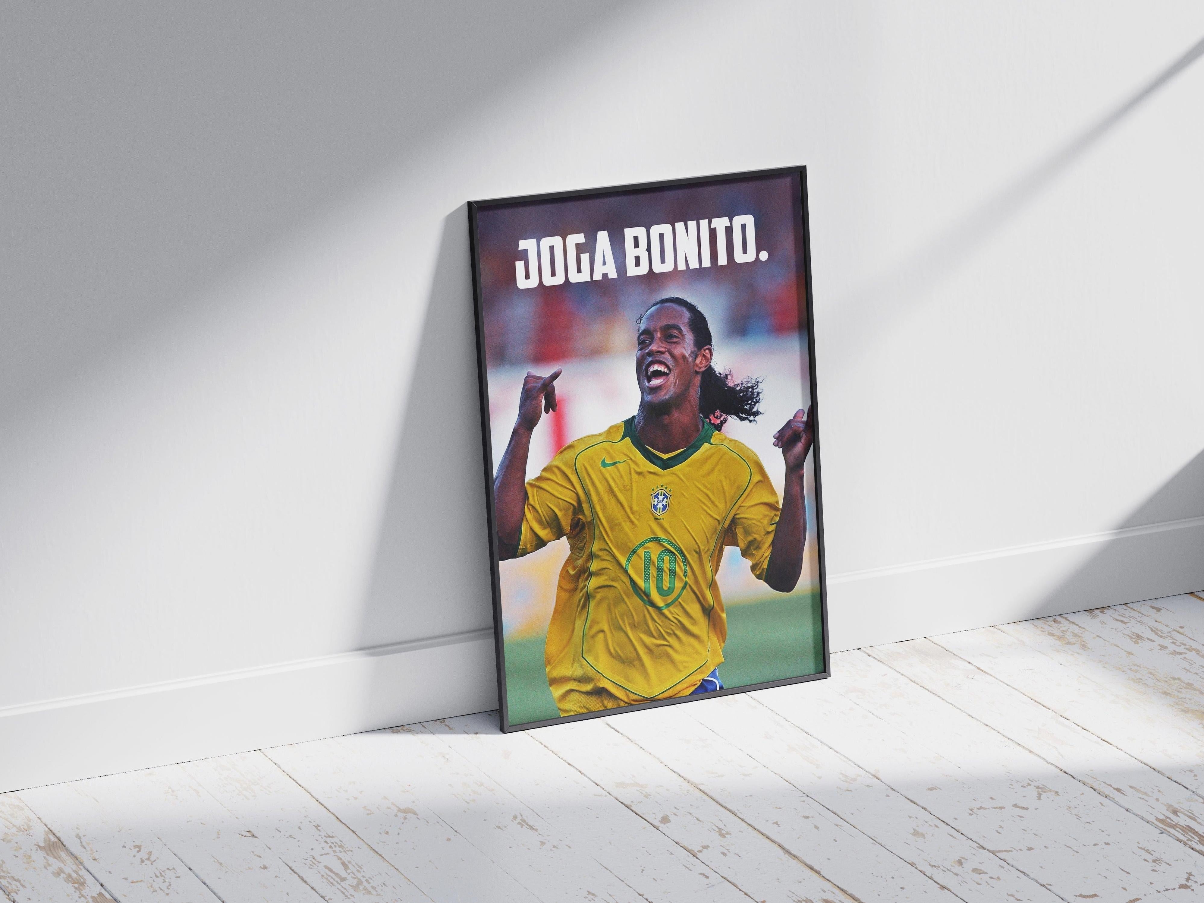The Retro1999 Ronaldinho Joga Bonito Poster 2 features the smiling soccer legend in a Brazil jersey and makes ideal decor for football fans, shown framed on a white wooden floor with sunlight casting stylish shadows.