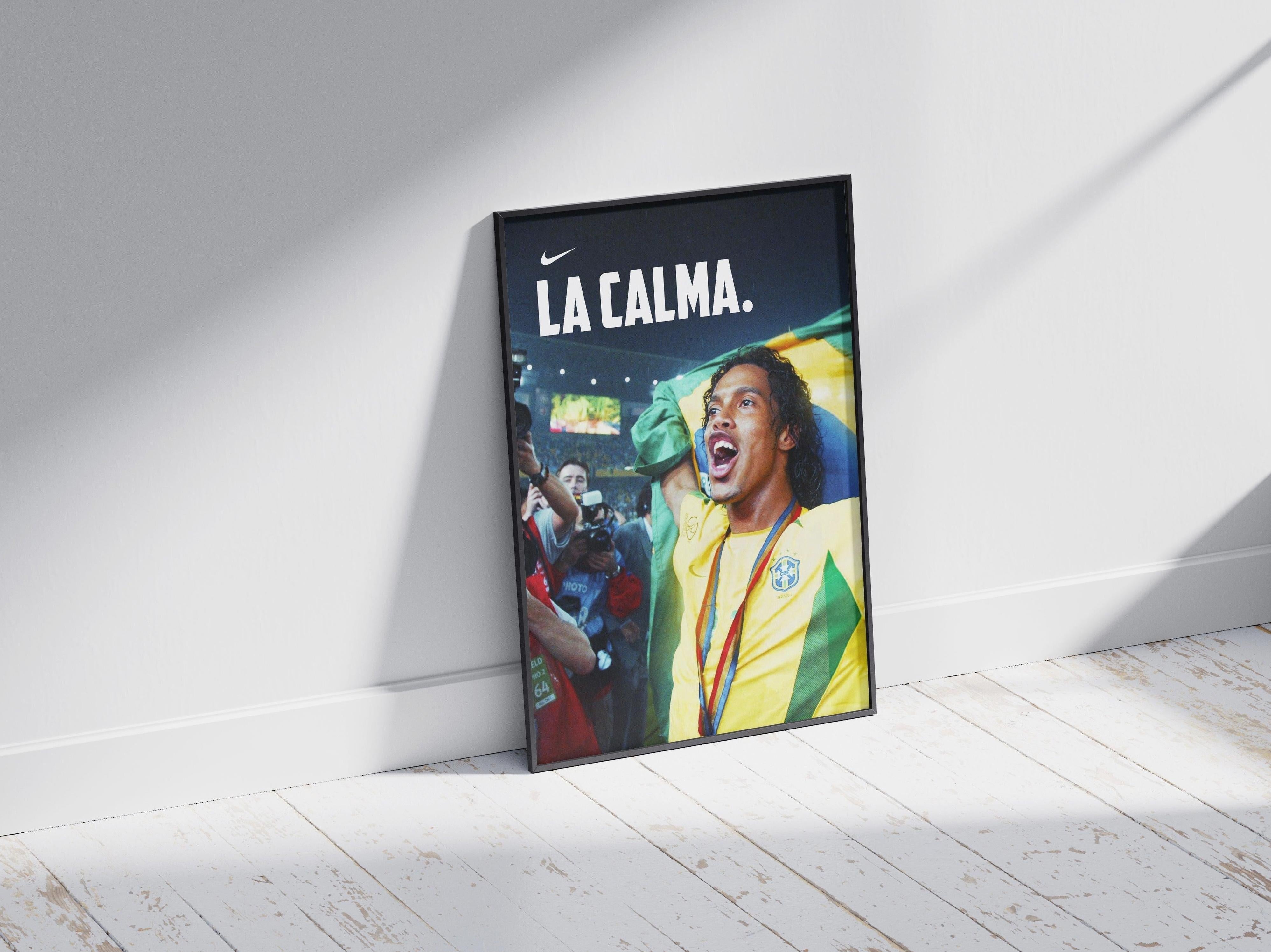The Retro1999 Ronaldinho La Calma Poster shows the Brazilian icon celebrating with a flag, the phrase LA CALMA., and a Nike logo—ideal memorabilia for any FIFA World Cup 2002 fan.