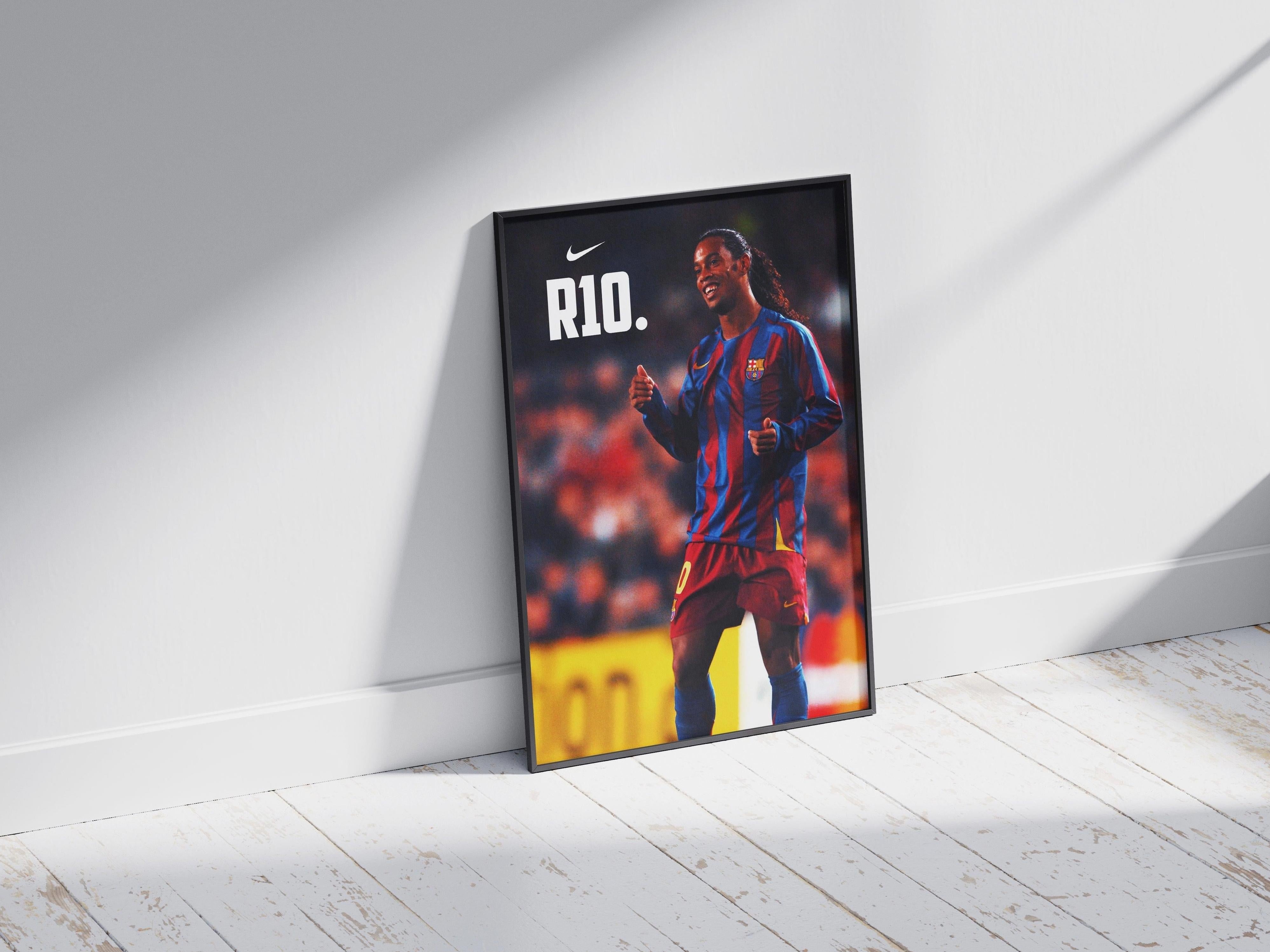 Perfect for football fans, the Retro1999 Ronaldinho R10 Poster shows him in a blue and red striped jersey with R10 and the Nike logo, framed and set on a sunlit wooden floor against a white wall.
