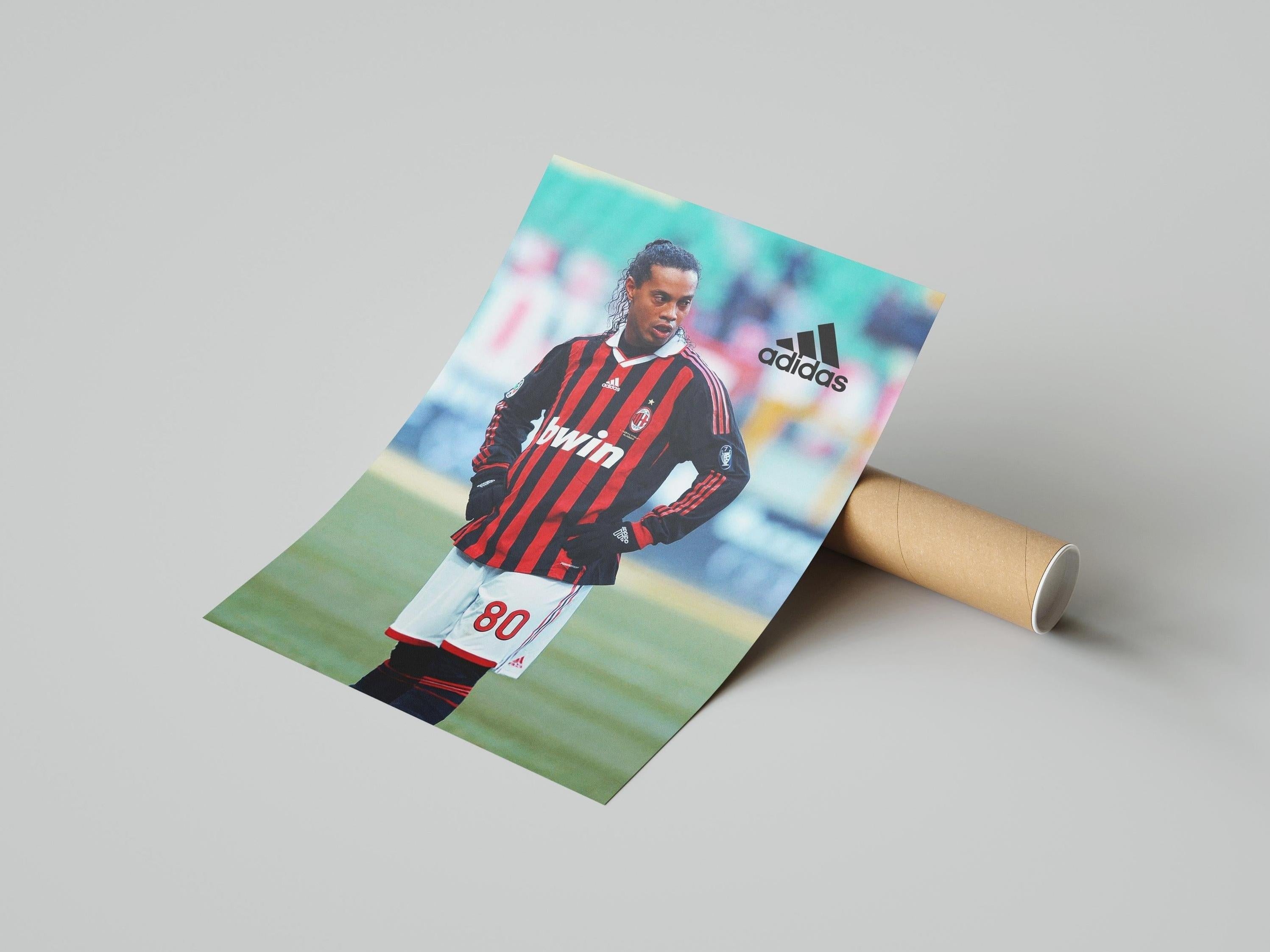 The Ronaldinho x AC Milan Poster by Retro1999 features Ronaldinho in his number 80 jersey, standing on the field, with visible Adidas and bwin logos. The poster comes rolled for easy display.