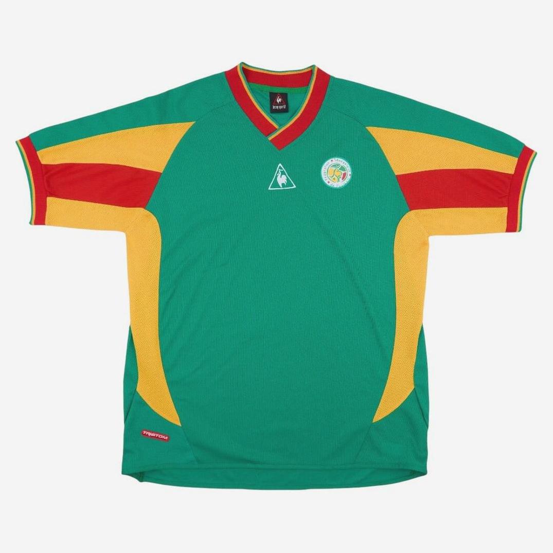 The Retro1999 Senegal 2002 Away Shirt is a green soccer jersey with yellow and red accents, short sleeves, red V-neck, and two chest logos—a tribute to Senegalese football and the iconic 2002 design.
