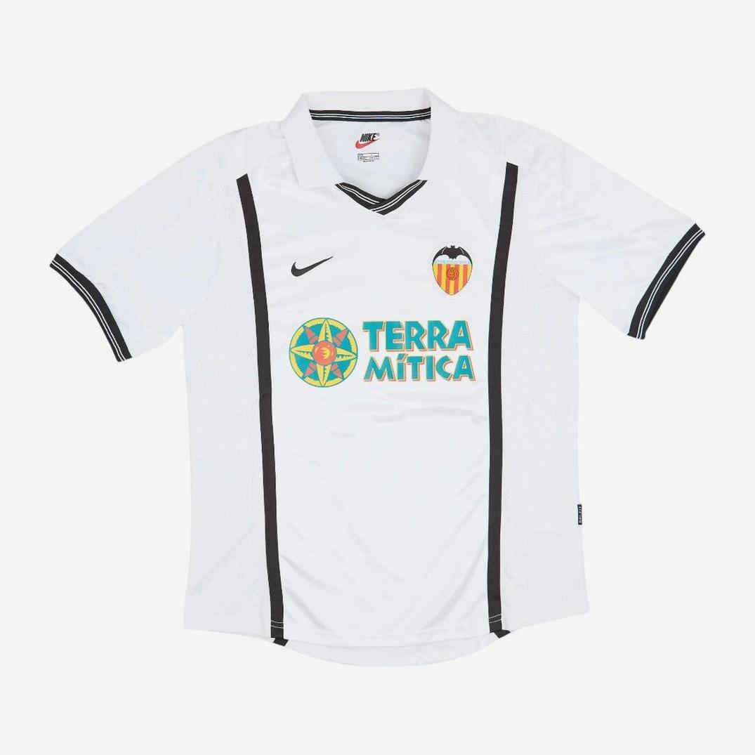 The Retro1999 Valencia CF 2000-01 Home Shirt features a classic white design with black trim, club crest, Nike logo, and Terra Mítica sponsor—an essential retro kit for any football fan.