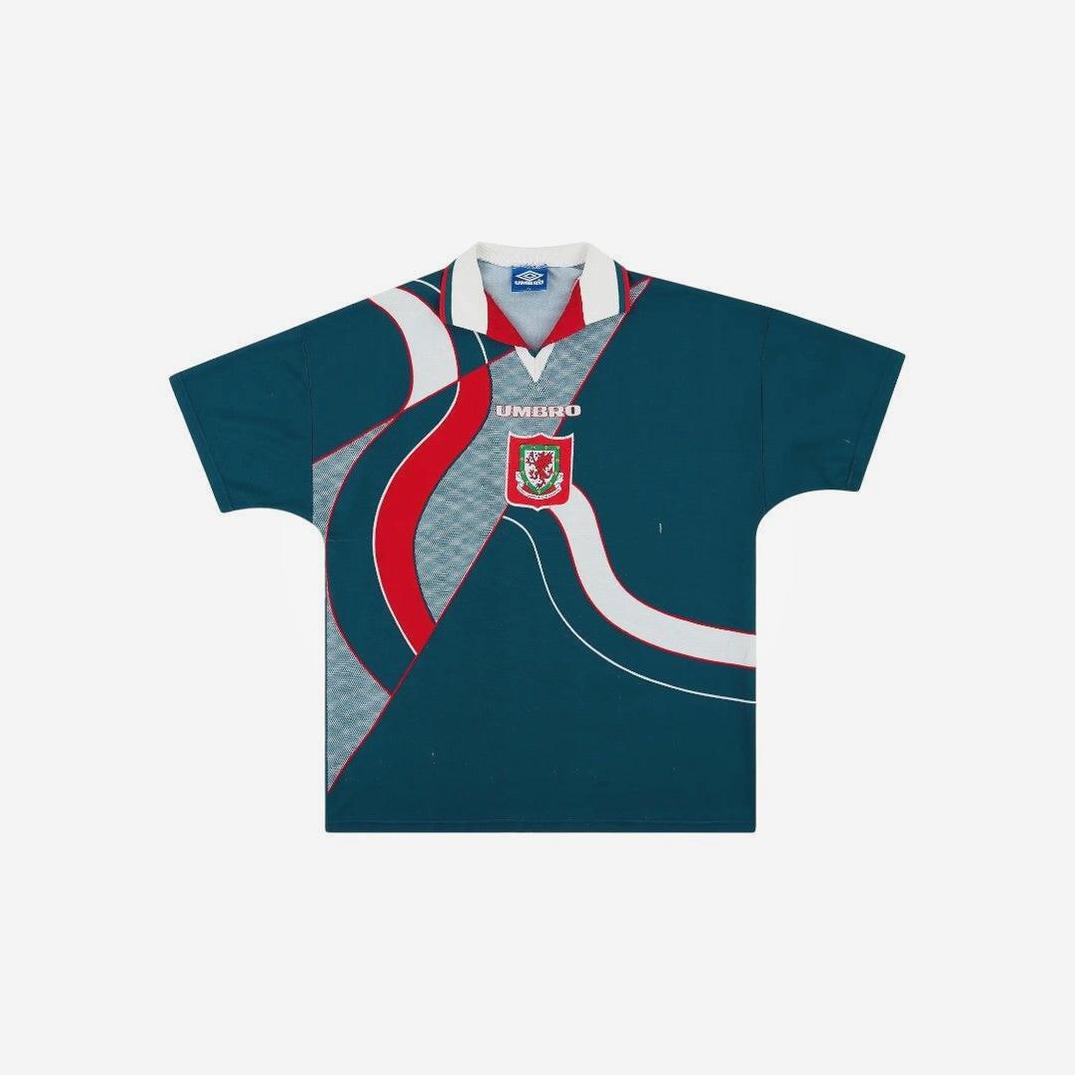 The Wales 1995/96 Away Shirt by Retro1999 features vintage teal and gray colors, curved red and white stripes, a collar, and a dragon crest below the white UMBRO logo—ideal for Welsh football fans and lovers of retro style.