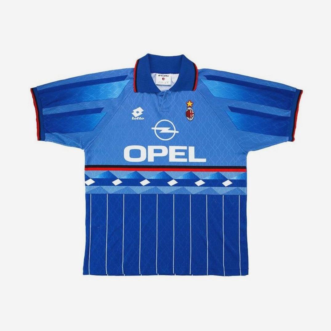 The AC Milan 1995-96 Third Kit by Retro1999 features a blue design with red and black accents, diamond chest pattern, white pinstripes, Lotto and Opel logos, plus the club crest with a star—perfect for retro football kit fans.
