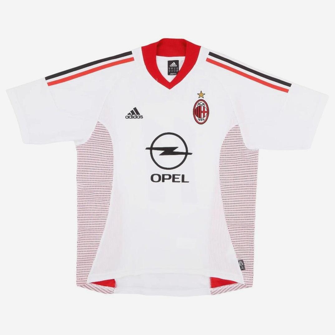 The AC Milan 2002-03 Away Shirt by Retro1999 features white fabric with red and black details, classic Opel sponsor, Adidas logo, and gold-star AC Milan crest—a legendary football kit.