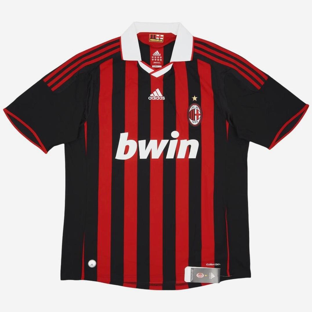 The Retro1999 AC Milan 2009-10 Home Shirt showcases red and black vertical stripes, a classic white collar, gold star above the badge, and bwin sponsor—an iconic retro kit for all football fans.