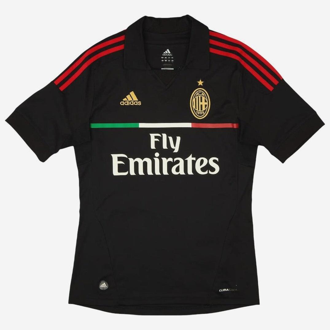 The AC Milan 2011-12 Third Shirt by Retro1999 features red shoulder stripes, gold Adidas logo, club crest, Fly Emirates sponsor, and an Italian flag stripe—an essential retro kit for dedicated AC Milan fans.