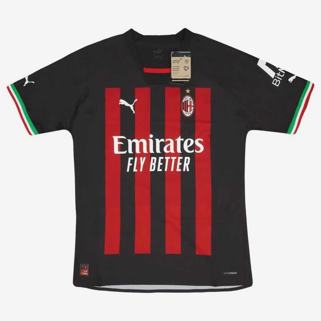 The Retro1999 AC Milan 2022-23 Home Shirt features black and red stripes, Emirates Fly Better sponsor, Puma logo, Italian flag sleeve accents, and a collar tag for authenticity.