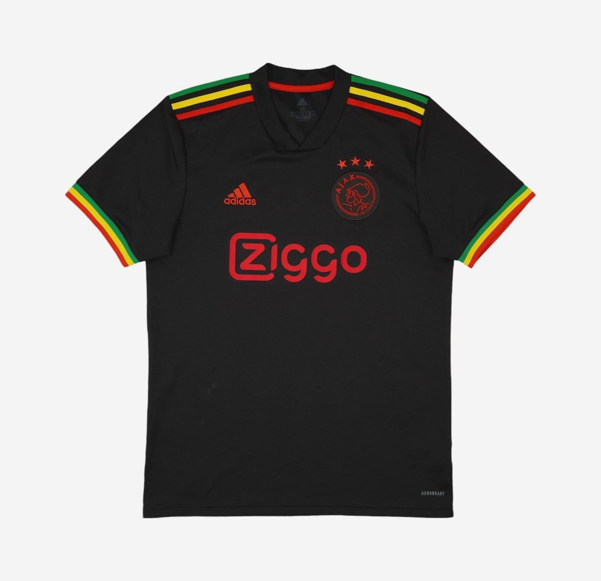 A must-have for any fan, the Retro1999 Ajax 2021-22 Third Shirt is black with red Ziggo and Adidas logos, crest, and unique green, yellow, and red shoulder stripes inspired by Rastafari colors for a retro kit vibe.