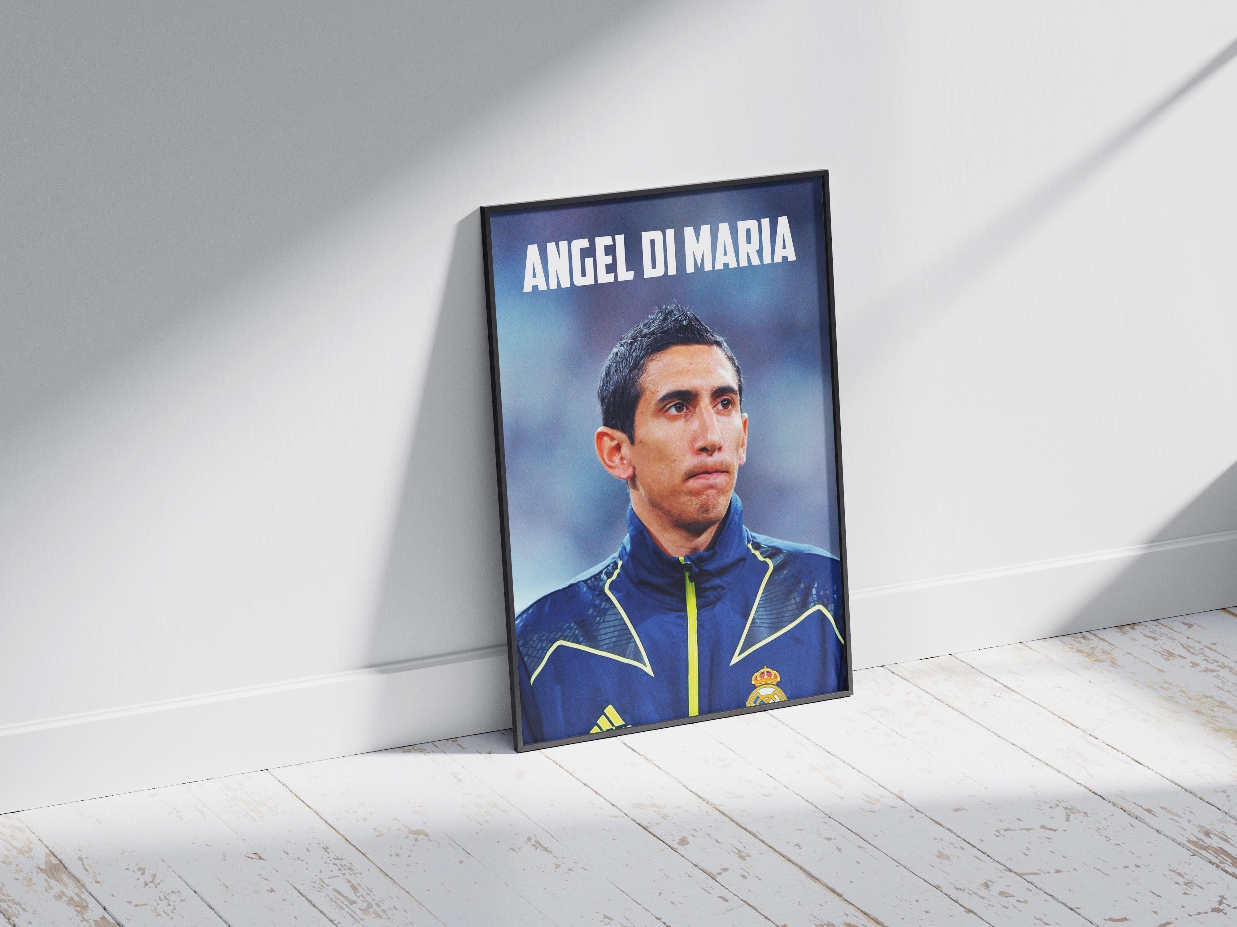 The Retro1999 Angel Di Maria RMA Poster, framed and iconic, leans against a white wall on a light wooden floor as sunlight creates soft shadows.