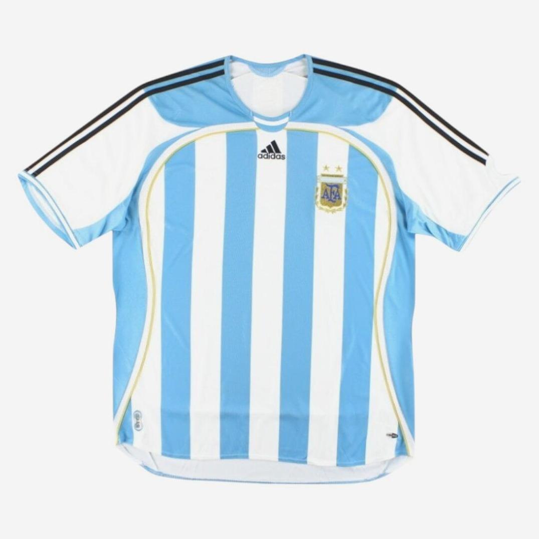 The Retro1999 Argentina 2006 Home Shirt features iconic light blue and white stripes, black shoulder stripes, two-star team crest, and a retro vibe—perfect for true fans.