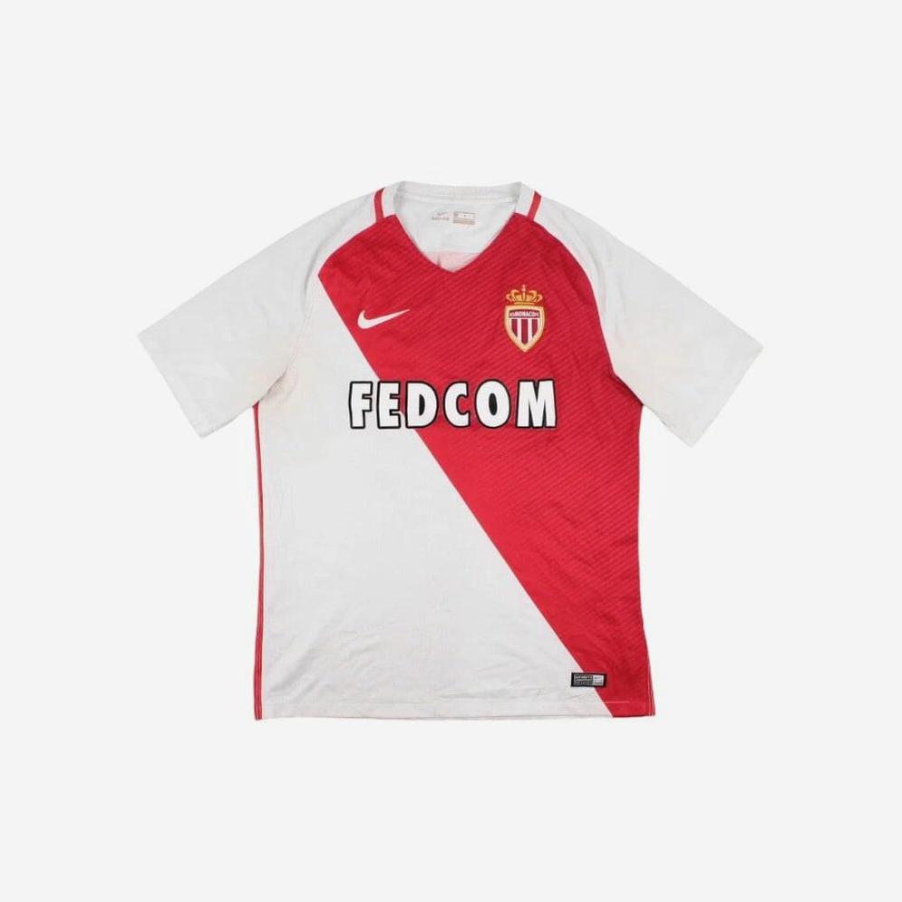 The Retro1999 AS Monaco 2016-17 Home Shirt features a white and red design with a bold diagonal stripe, club crest, Nike logo, and FEDCOM sponsor—capturing the classic style of this iconic Ligue 1 team.