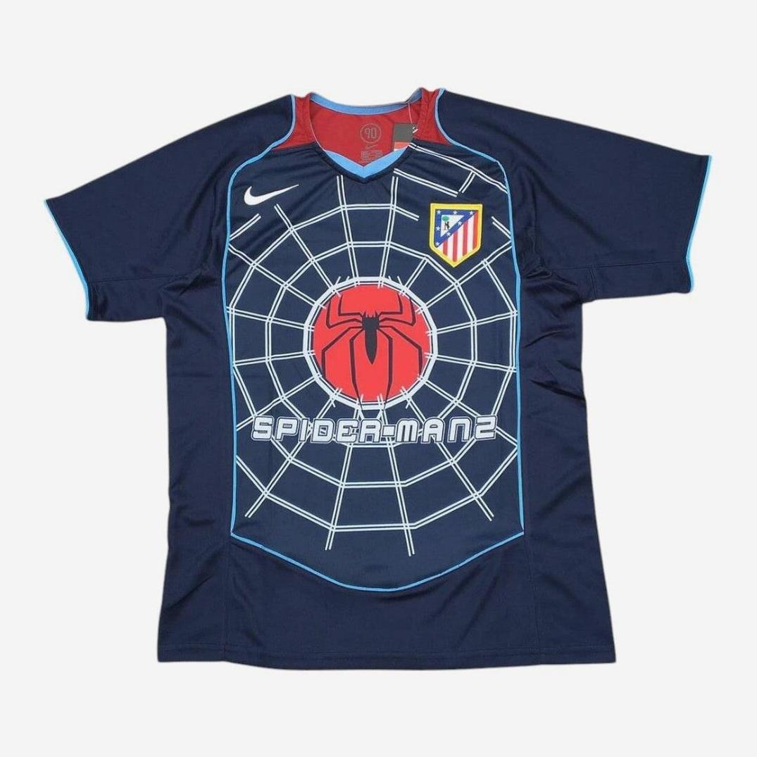 The Retro1999 Atletico Madrid 2004-05 Away Shirt is a dark blue vintage football jersey with a Spider-Man web design, red spider logo, SPIDER-MAN 2 text, and Atlético Madrid crest—ideal for retro shirt fans.