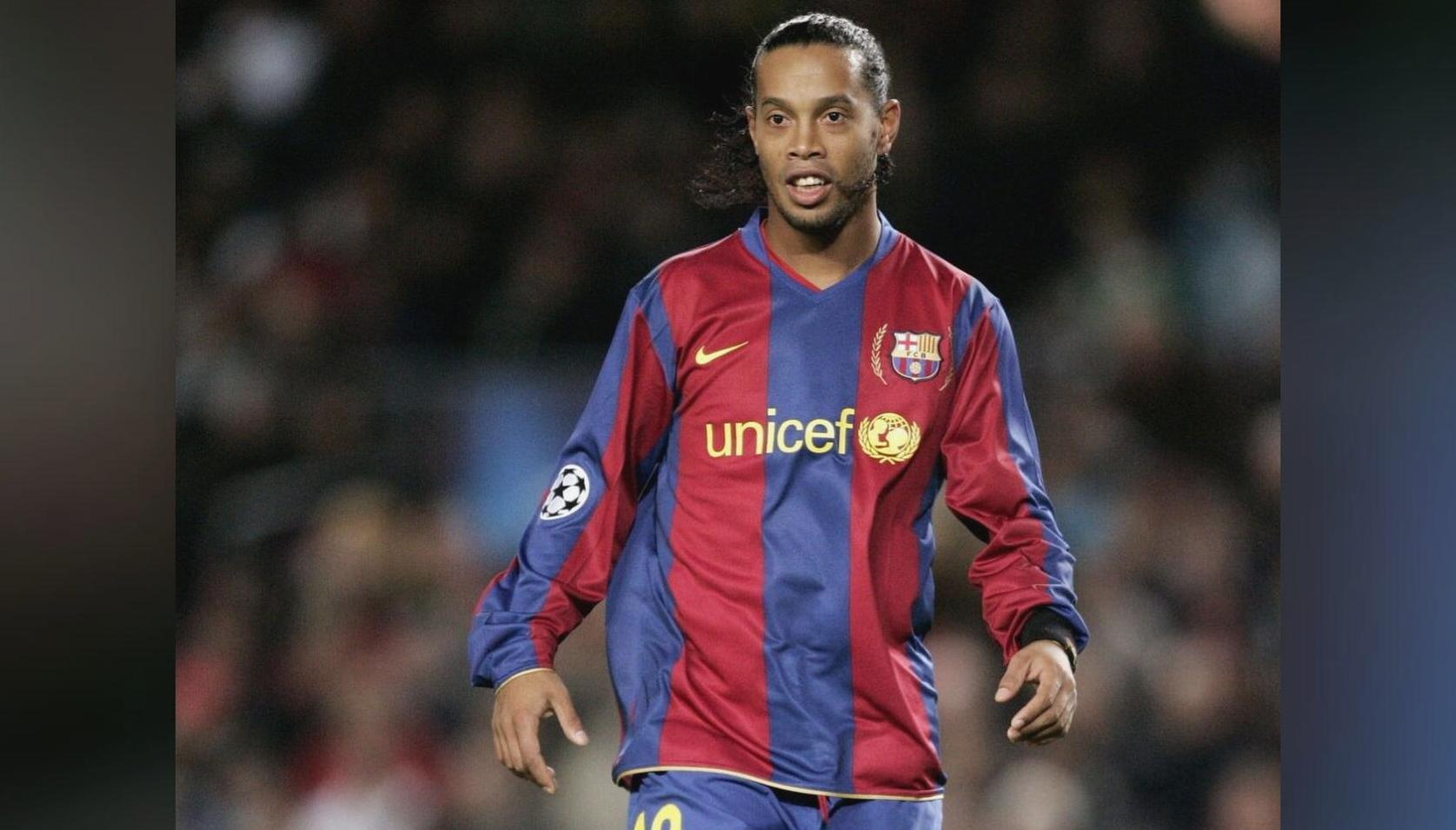 A football player wears the Retro1999 Barcelona 2007-08 Home Shirt, complete with unicef and UEFA Champions League logos, on the field during a Frank Rijkaard season match.