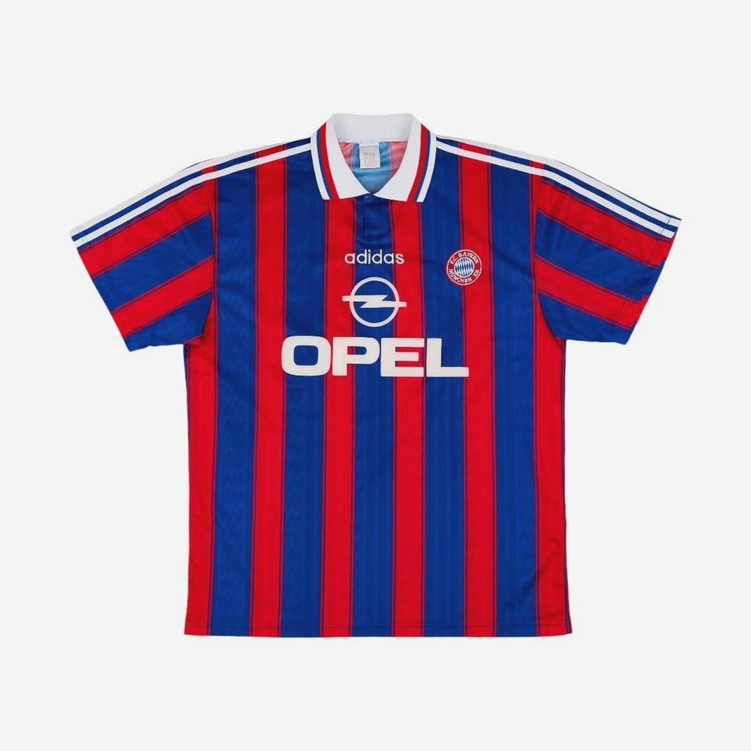 The Retro1999 Bayern Munich 1995-97 Home Shirt features red and blue stripes, white Adidas and Opel logos, a white collar with shoulder stripes, plus the club badge on the chest—a classic retro Bundesliga kit.