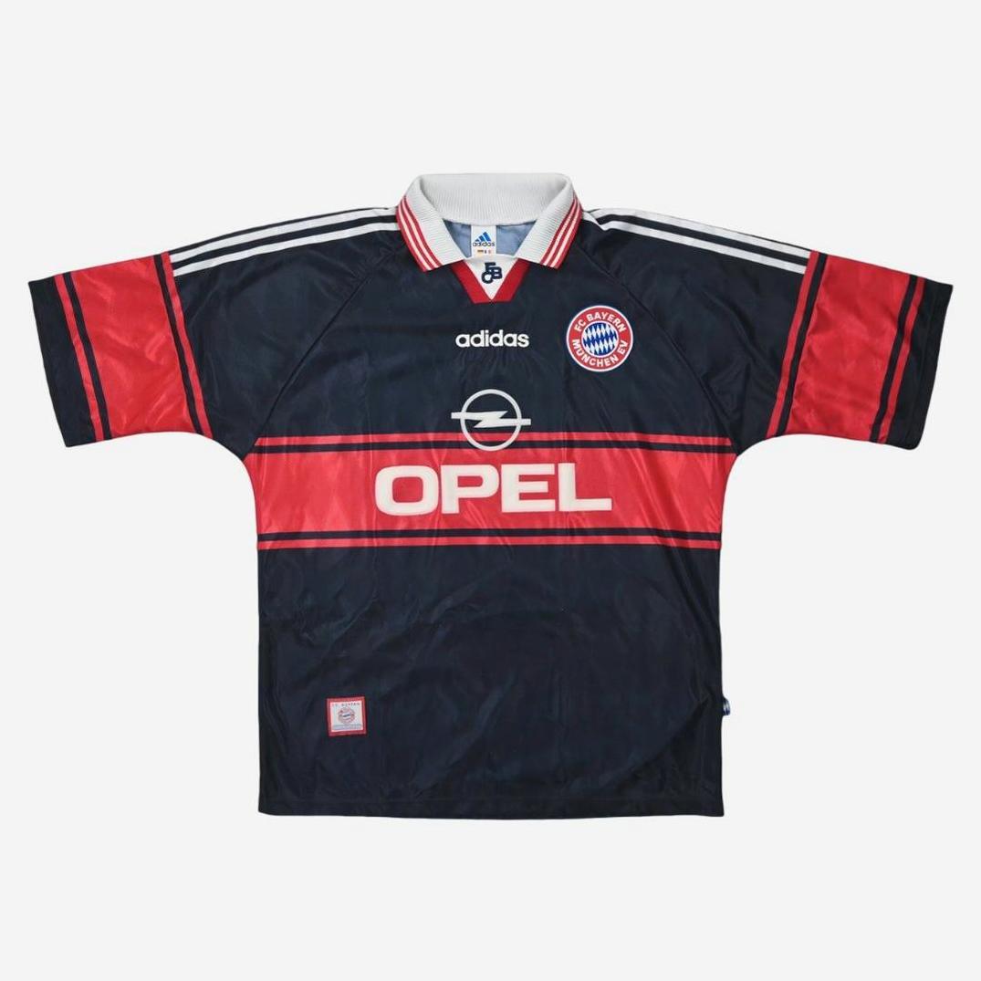 The Bayern Munich 1997-98 Away Shirt by Retro1999 features classic white stripes, the Opel logo, and club crest—a must-have for Bundesliga fans inspired by the iconic retro design.