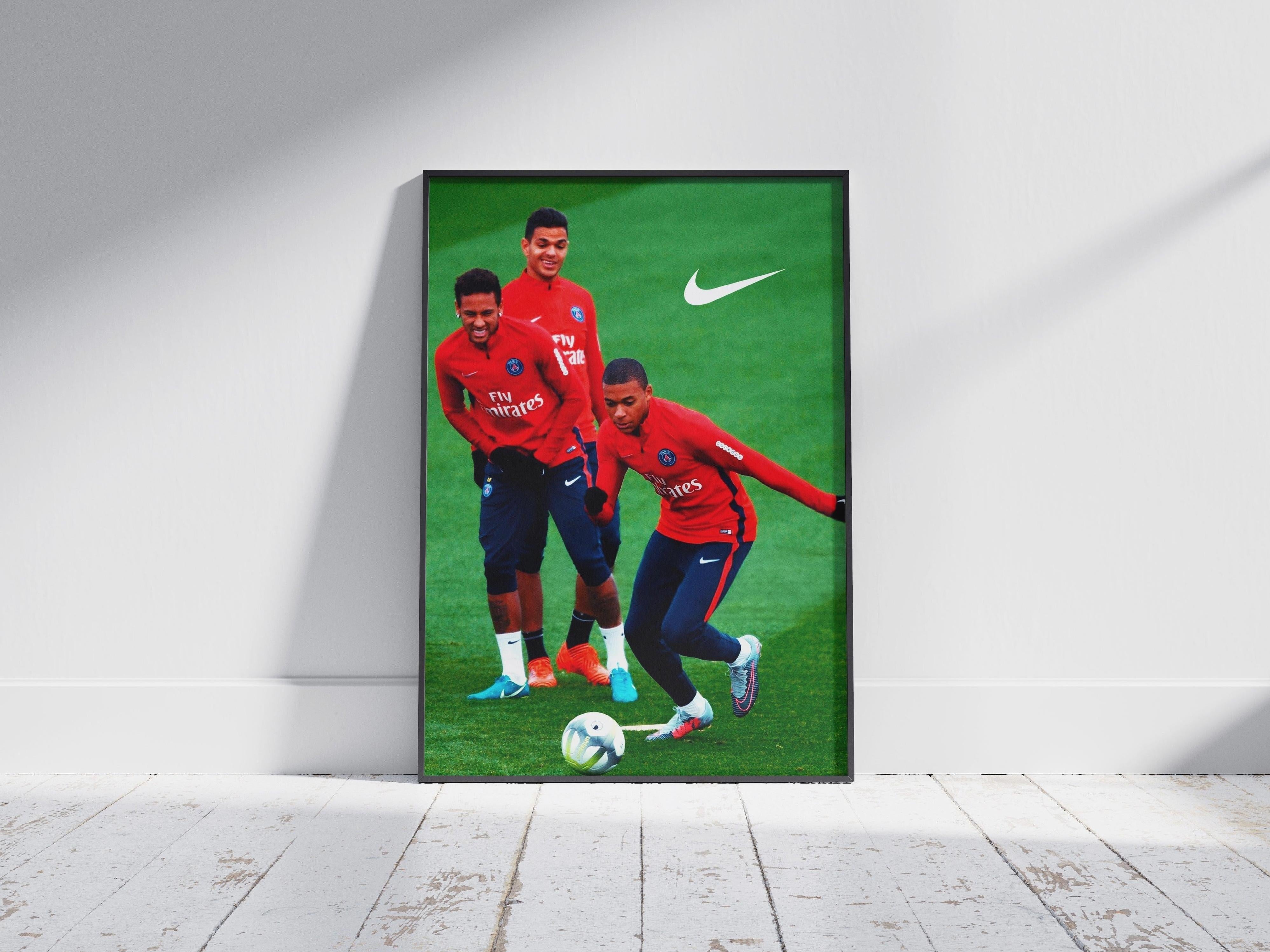 The Retro1999 Ben Arfa x Neymar x Mbappe Poster features the trio in red jerseys on grass—one dribbling, two smiling behind—with the Nike logo in the top right. The framed poster leans against a white wall.