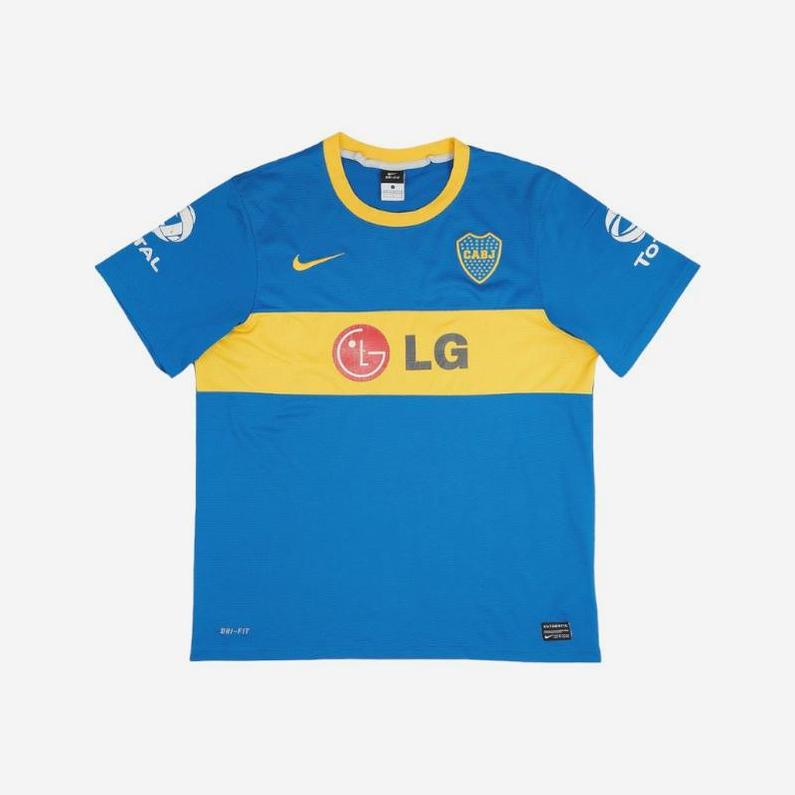 The Retro1999 Boca Juniors 2010-11 Home Shirt features blue and yellow colors, a yellow stripe, chest team badge, LG sponsor logo, Nike logo, vintage design, and white sleeve sponsor logos.