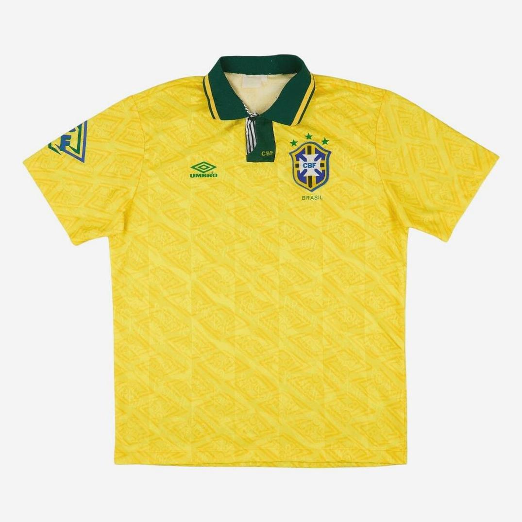 The Retro1999 Brazil 1991-93 Home Shirt features a yellow design with green collar and trim, chest team crest, Umbro-style logo, subtle geometric pattern, and a sleeve patch, inspired by the classic national team jersey.