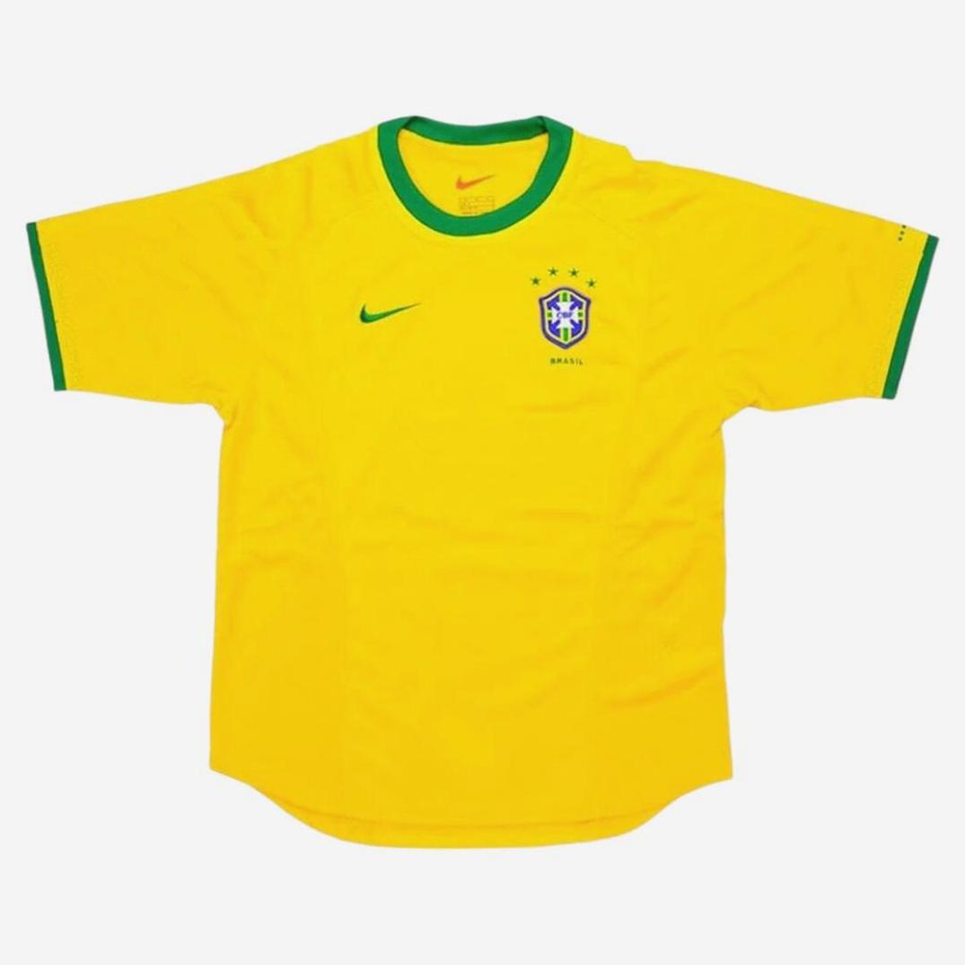 A classic Brazil 2000 Home Shirt by Retro1999 in yellow with green trim, featuring the team crest with five stars and Nike logo on the chest—retro style inspired by Brazil’s iconic national team kit.
