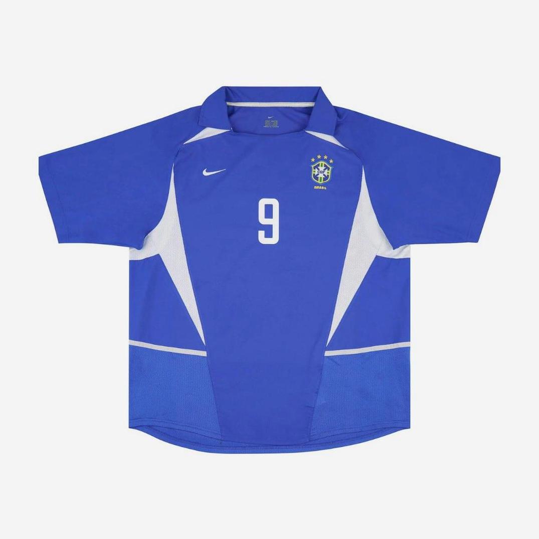 Retro1999’s Brazil 2002 Away Shirt features white accents, a bold number 9 on the front, Brazil crest, Nike logo on the chest, and short sleeves—a classic retro kit for any World Cup fan.
