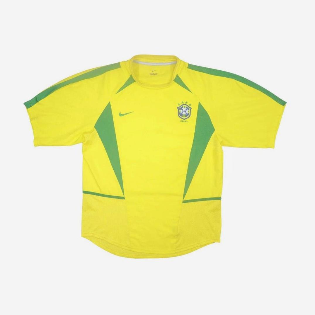 The Retro1999 Brazil 2002 Home Shirt is a yellow soccer jersey with green accents, Nike logo, and five-star national crest—ideal for football fans—shown on a plain white background.
