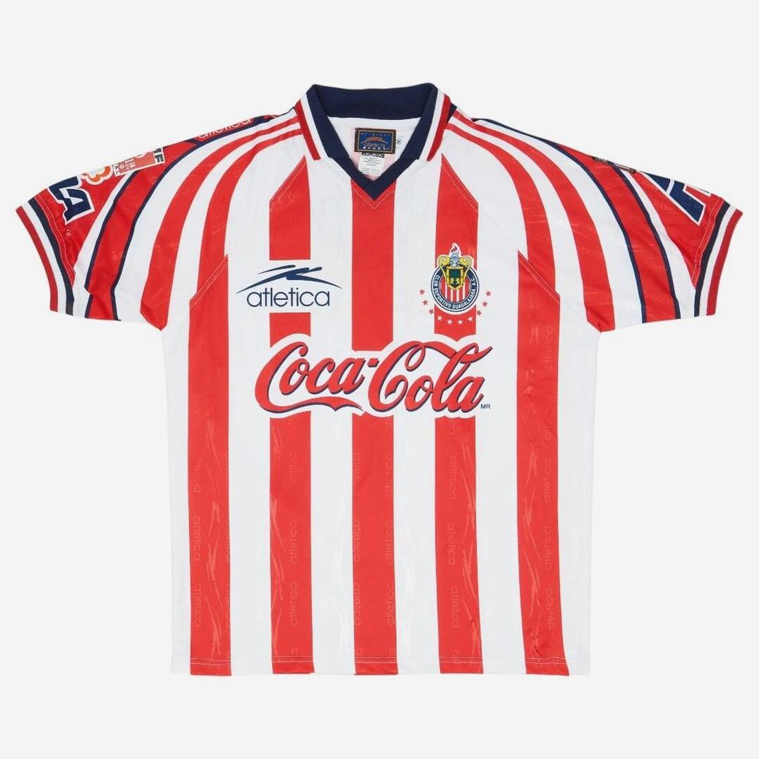 The Chivas 1998-99 Home Shirt by Retro1999 features red and white stripes, blue collar and cuffs, the club crest, Atlética and Coca-Cola logos, and number 23 on the sleeves—ideal for fans of this classic retro kit.