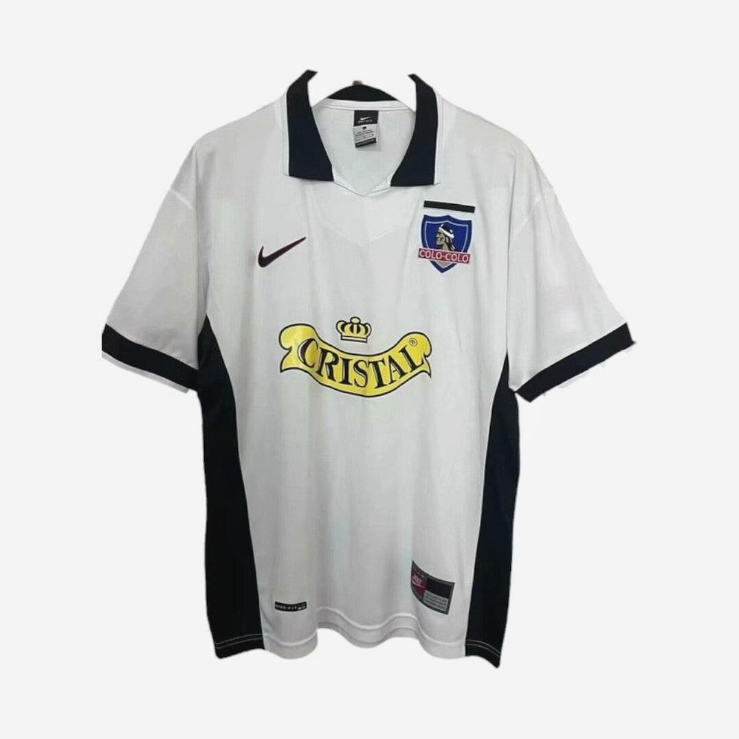 The Retro1999 Colo Colo 1997-98 Home Shirt is a white and black soccer jersey with a black collar, retro style, club crest, Nike logo, and Cristal sponsor—ideal for any football fan.