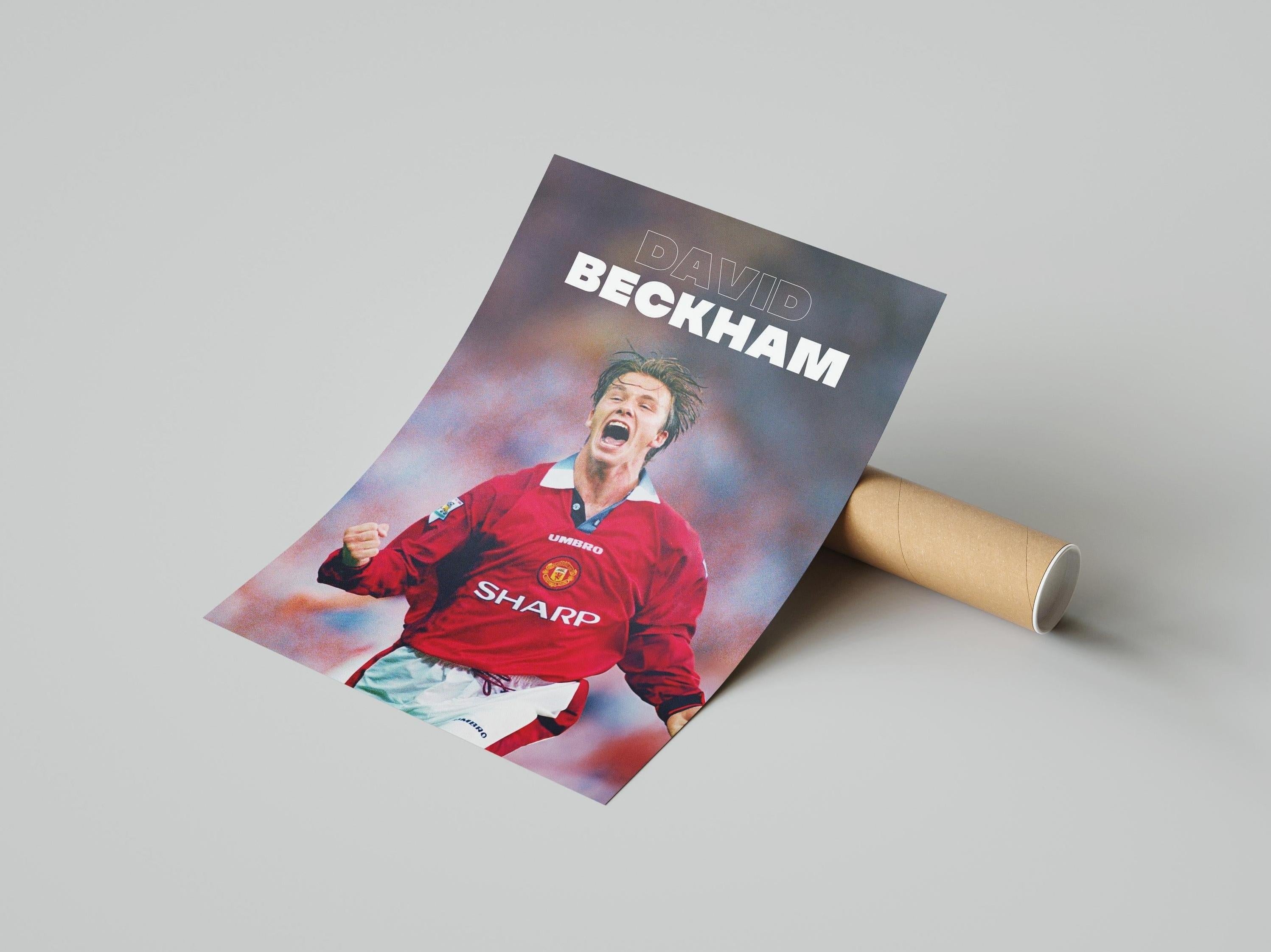 The Retro1999 David Beckham x Manchester United Poster showcases the soccer star in a red jersey with his name in bold white letters, rolled and displayed on a plain light surface.