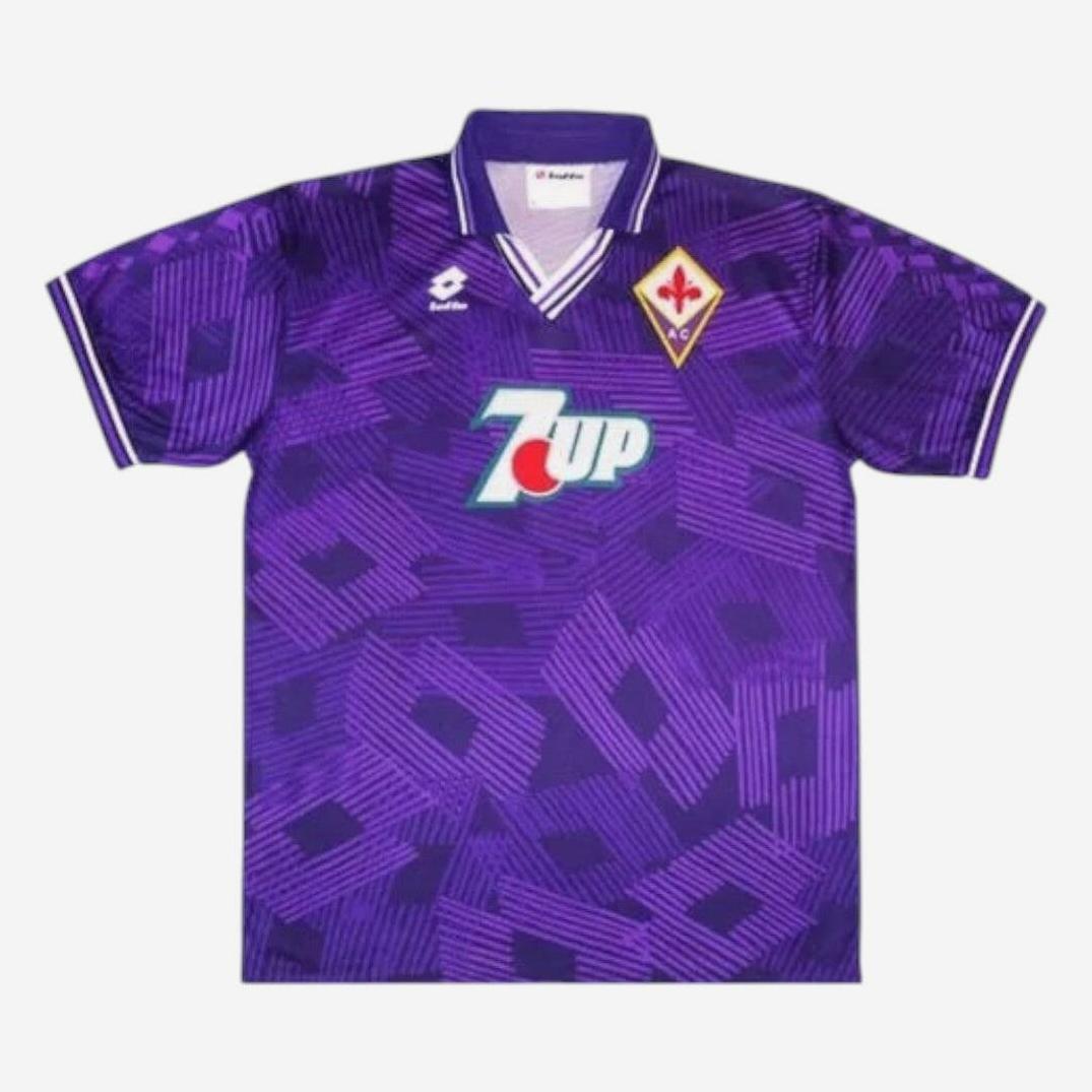 The Retro1999 Fiorentina 1992-93 Home Shirt has geometric patterns, a Lotto logo, club badge, bold 7UP sponsor, collar, and short sleeves with white and purple trim—classic Serie A retro style.