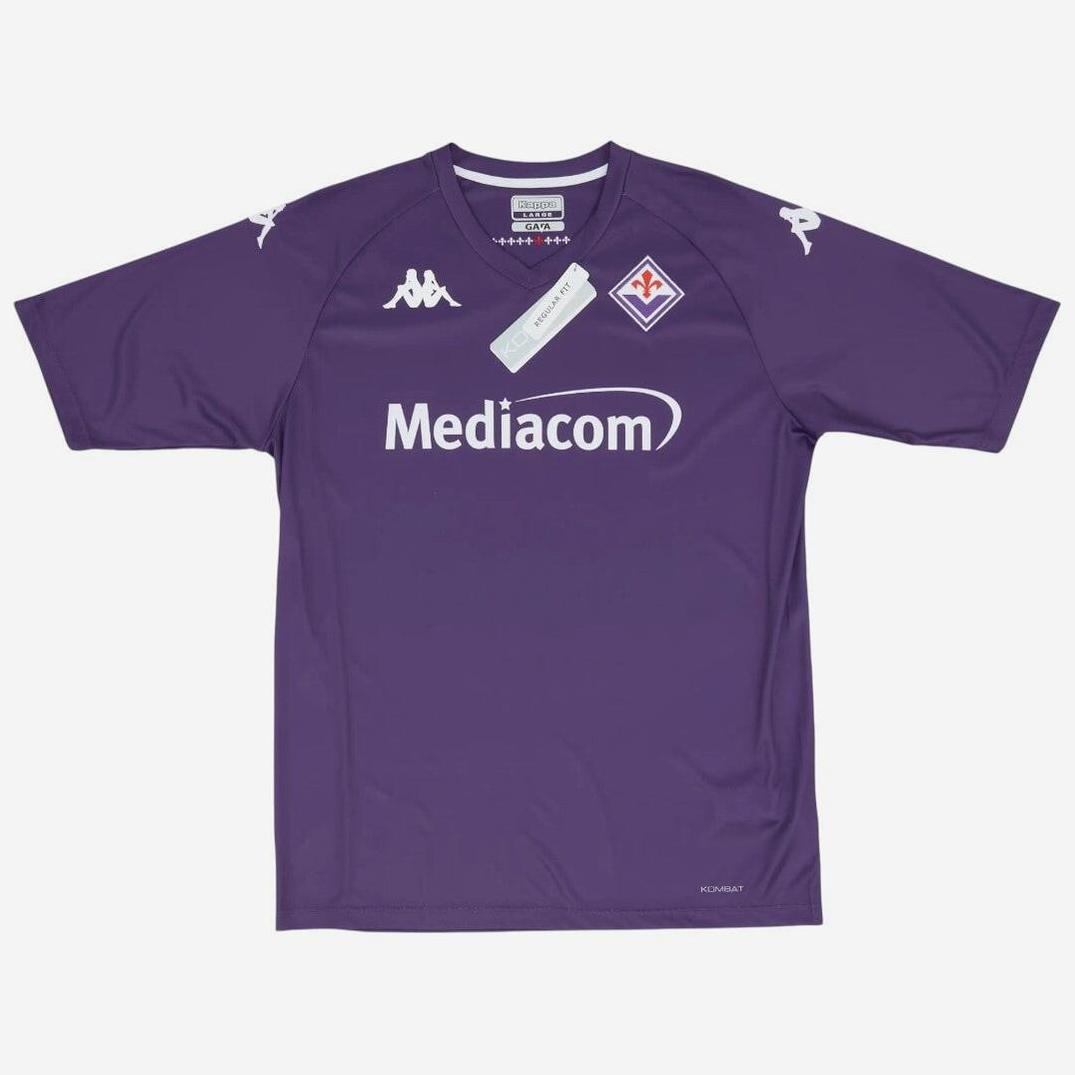 The Retro1999 Fiorentina 2024-25 Home Shirt features a purple design with white logos, Mediacom across the chest, Kappa logos on the shoulders, and a red fleur-de-lis badge. Includes a tag near the collar. Authentic Serie A jersey.