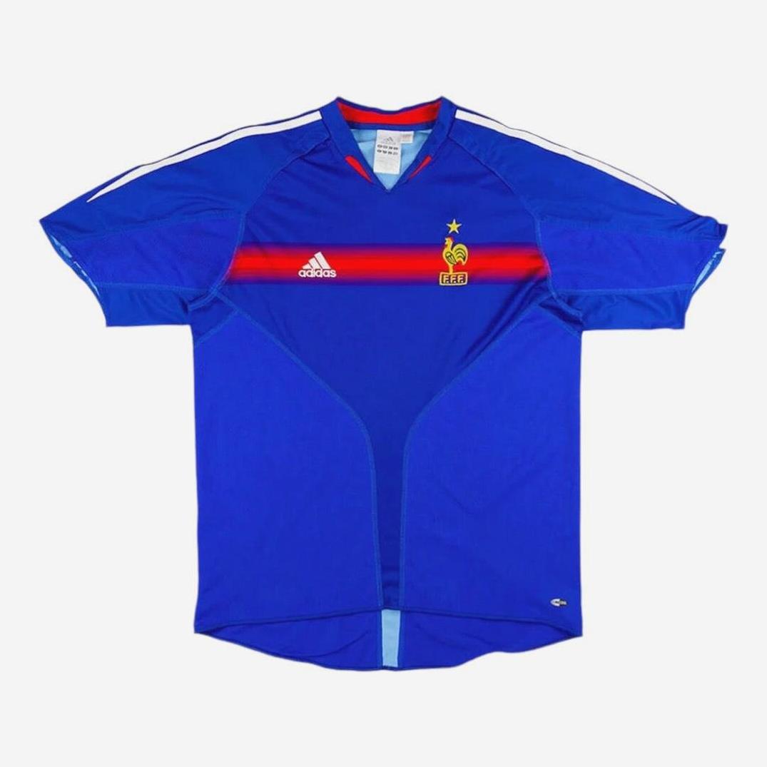 The France 2004 Home Shirt by Retro1999 is a blue retro kit featuring a red stripe, white Adidas logo, and the French Football Federation crest with a star—perfect for any fan of the French national team.