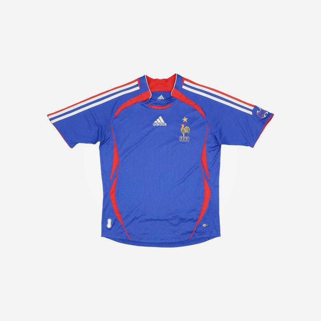 France 2006 Home Shirt by Retro1999, featuring blue design with white and red details, French Football Federation logo, gold star, and sponsor logos on chest and sleeves, displayed flat on a white background.