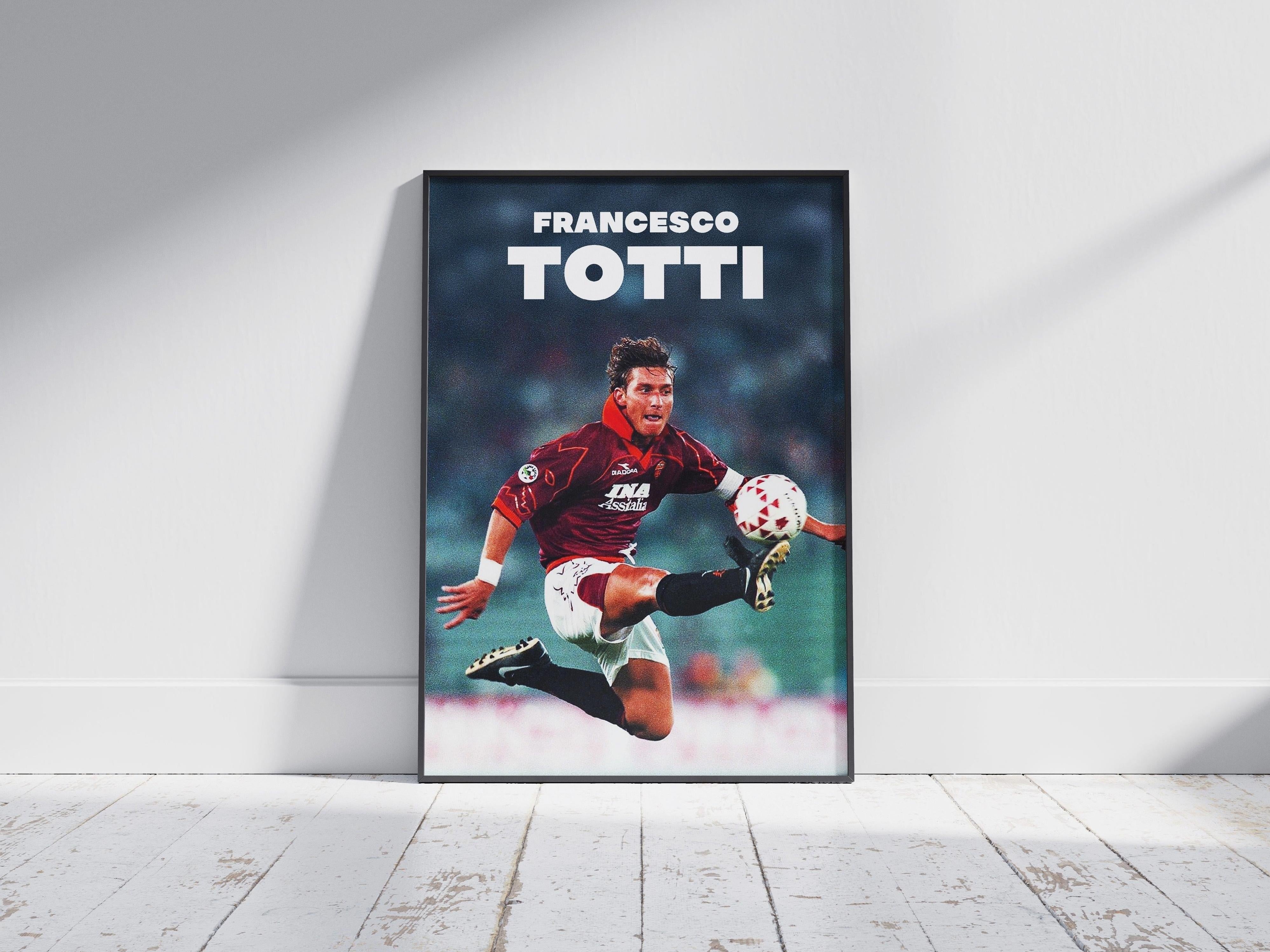 The Retro1999 Francesco Totti Poster features the football star mid-air in a red jersey, kicking a ball, with his name in bold white letters—a perfect framed collectible for any soccer fan.