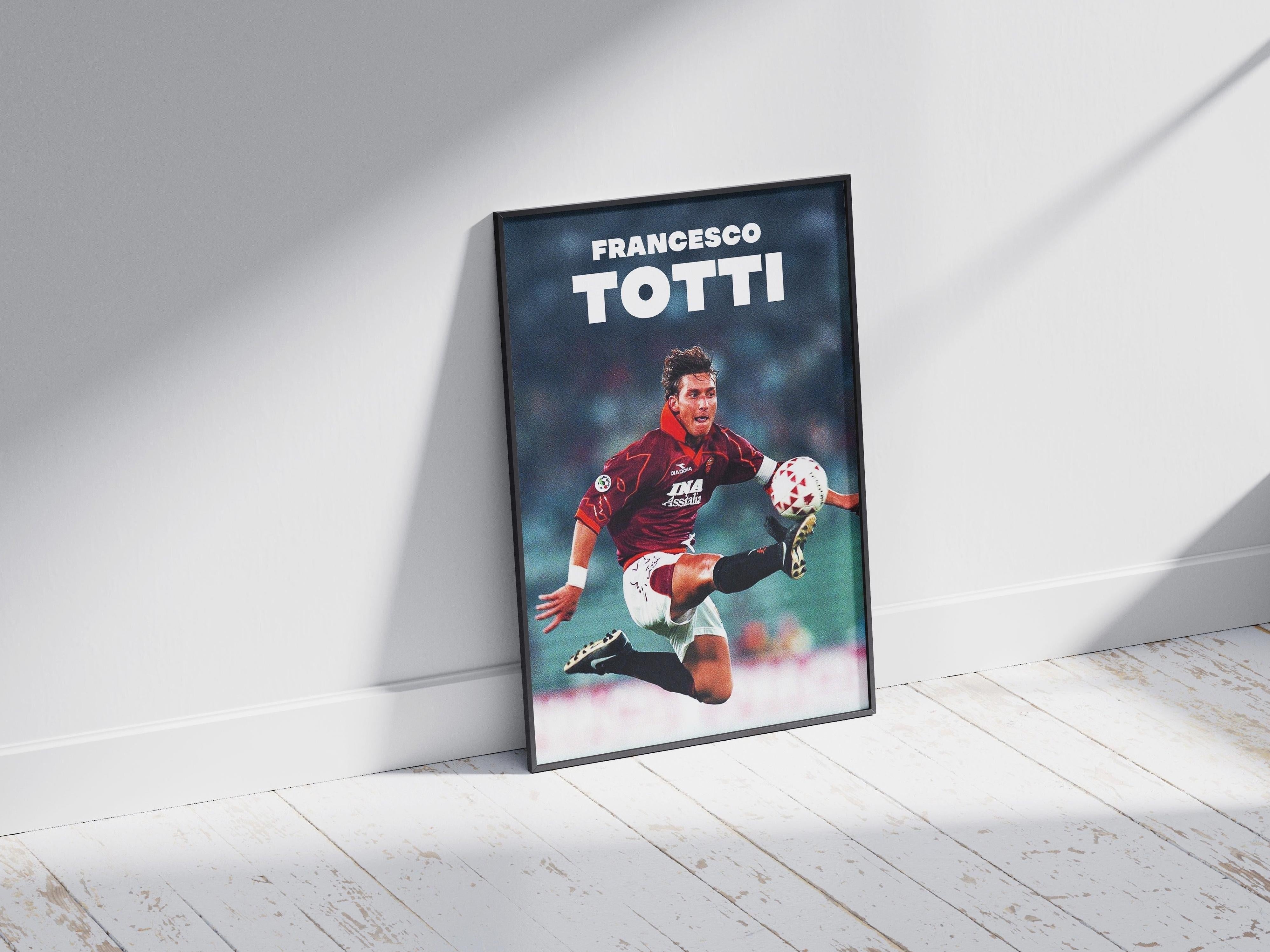 The Francesco Totti Poster by Retro1999 features a soccer player in mid-air on a white wooden floor, wearing a maroon jersey with FRANCESCO TOTTI in bold at the top—perfect sports memorabilia for football fans. Sunlight casts shadows nearby.
