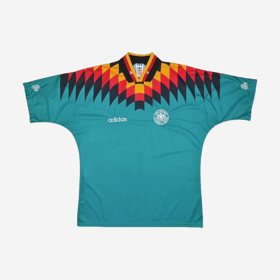 Inspired by the original, the Retro1999 Germany 1994 Away Shirt features a classic teal look with geometric red, black, and yellow shoulder and collar patterns plus the national team crest on the chest.