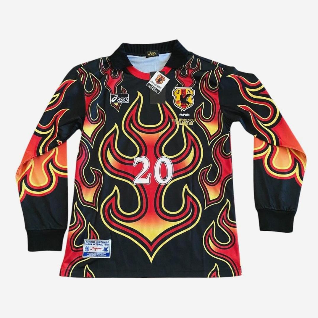 The Japan 1998 Goalkeeper Shirt Red Flame by Retro1999 is a long-sleeve black soccer jersey with red flame print, number 20, ASICS logo, chest crest, and retro-inspired details from the iconic Japan 98 kit.