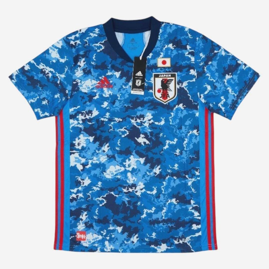 The Retro1999 Japan 2020/21 Home Shirt features a blue camo pattern, authentic team colors, red side stripes, an Adidas logo, and the Japan Football Association crest on the chest.