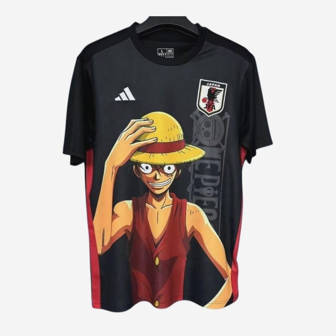 The Retro1999 Japan 2025-26 Special Edition Shirt is a black kit featuring One Piece’s Luffy with his straw hat and red vest, plus the Japan National Team logo—a bold, retro-inspired tribute for fans.