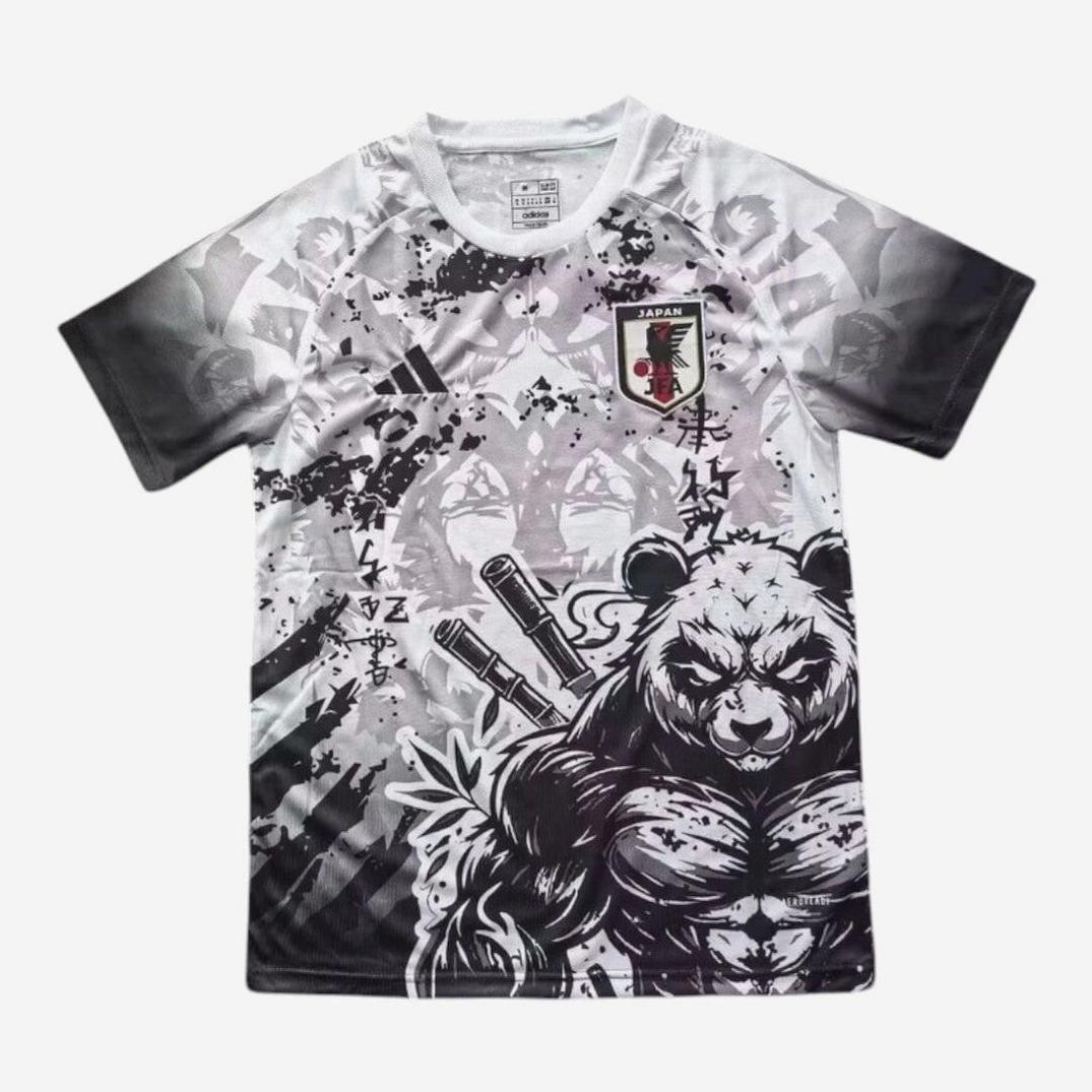 The Retro1999 Japan 2025-26 Special Edition Shirt features short sleeves, a bold black and white design with a muscular panda wielding swords, Japanese text, geometric patterns, and the national team logo on the chest.