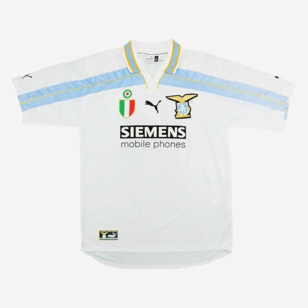 The Retro1999 Lazio 2000-01 Centenary Home Shirt features white with light blue and yellow accents, Puma logo, team badge, Scudetto patch, and Siemens Mobile sponsor—a classic piece for football history fans.