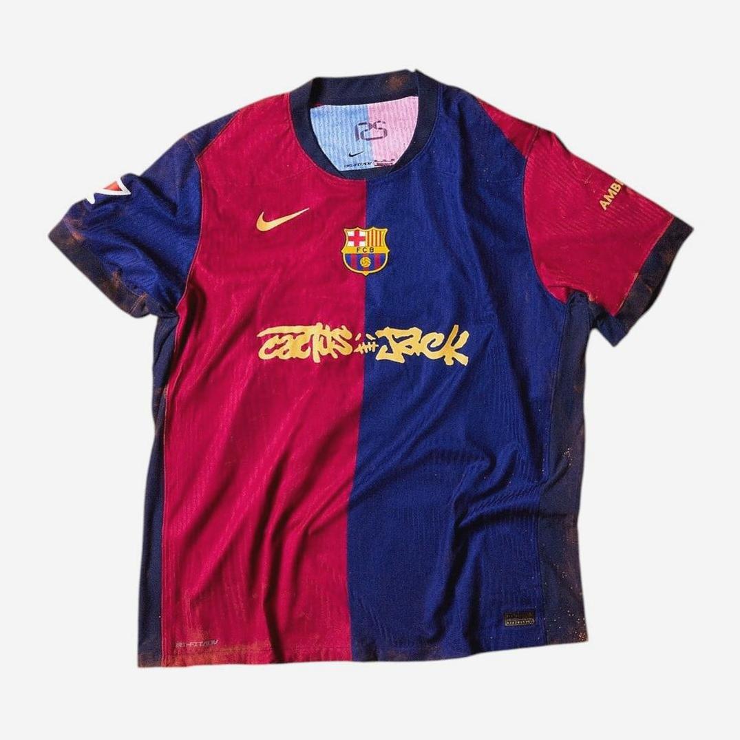 The Retro1999 Limited Edition FC Barcelona X Travis Scott Shirt features blue and red vertical halves, yellow Nike logo, club crest, graffiti-style Cactus Jack text, and a yellow Rakuten sponsor logo—perfect for football fans.