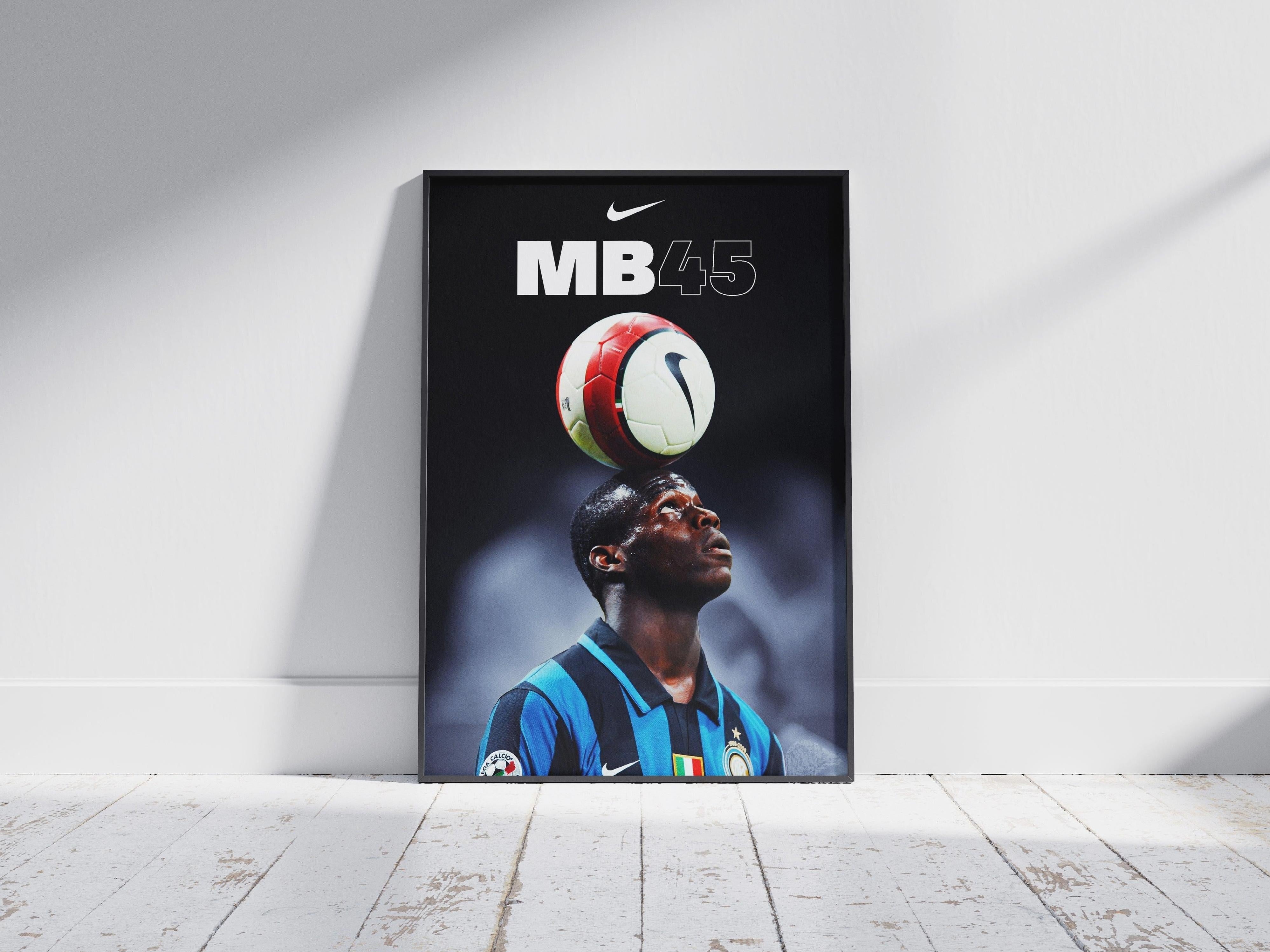 A framed Mario Balotelli Inter Milan Poster by Retro1999 rests on a wooden floor, featuring Balotelli in an Inter Milan jersey balancing a ball on his head with MB45 and the Nike logo above—capturing his 2007-2008 Serie A season.