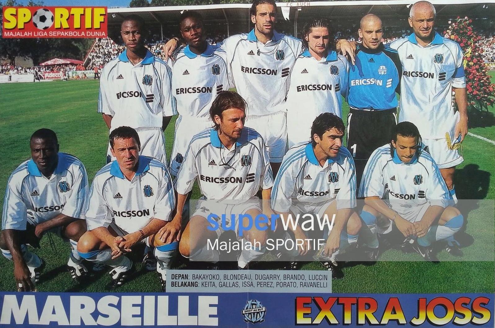 A soccer team wearing the Retro1999 Marseille 1998-99 Home Shirt poses for a group photo on the field, with standing and kneeling players, empty stadium seats, green grass, and overlaid text and logos on this classic kit image.