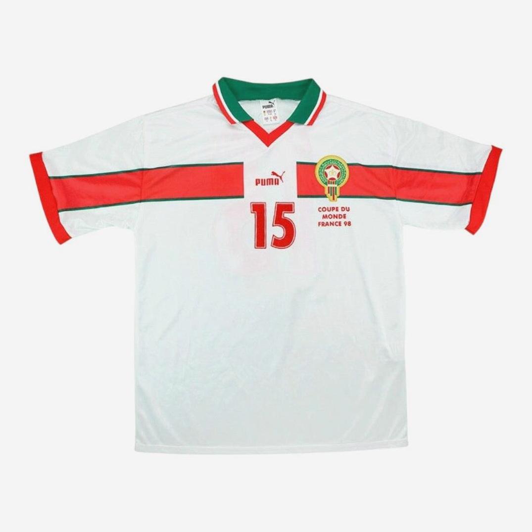 The Retro1999 Morocco 1998 Away Shirt is white with red and green accents, features number 15 and a Morocco badge, and displays Coupe du Monde France 98 in tribute to the 1998 FIFA World Cup.
