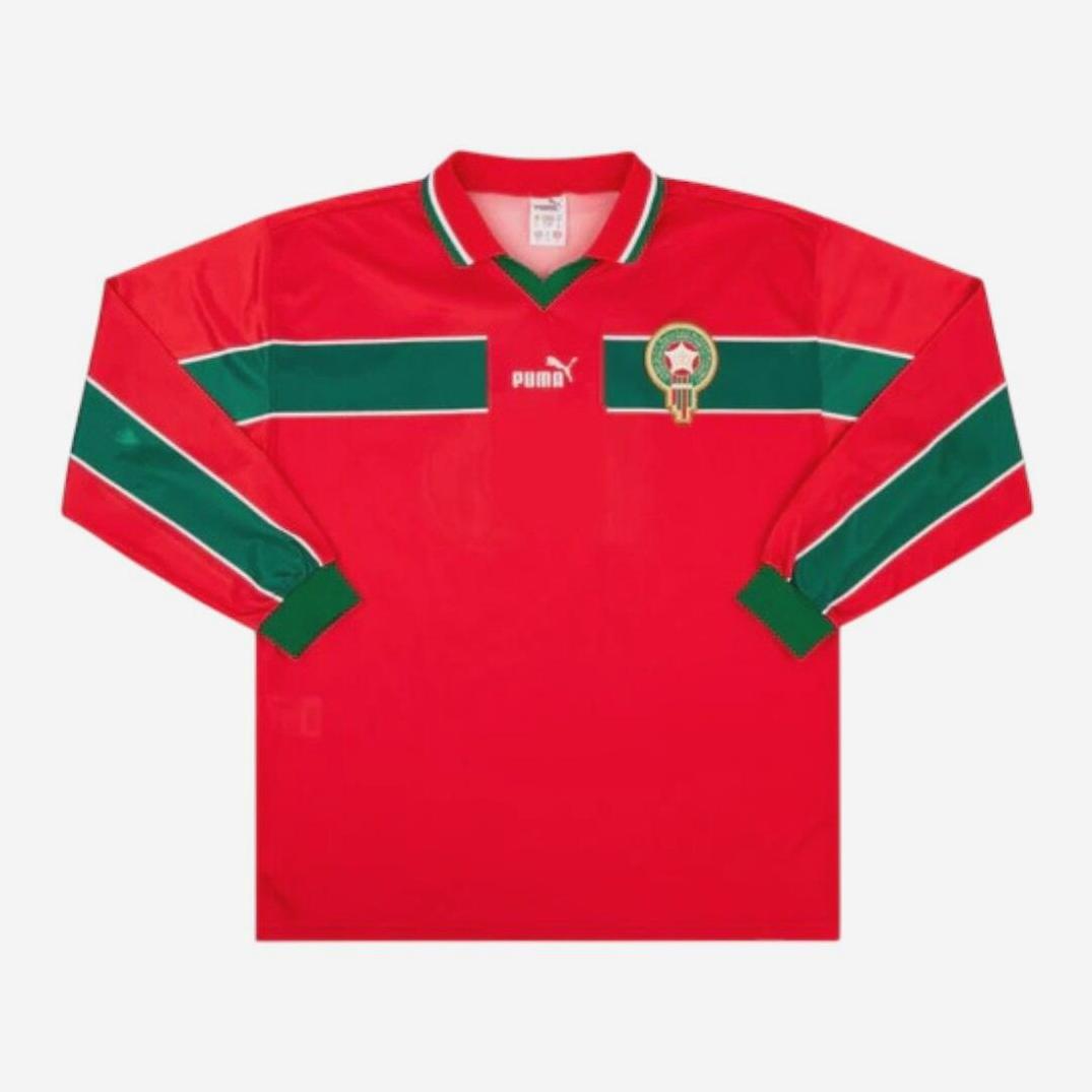 The Retro1999 Morocco 1998 Third Shirt Longsleeve features a red design with green stripes on the sleeves and chest, plus the Moroccan crest and Puma logo—an authentic tribute to the classic 1998 kit.