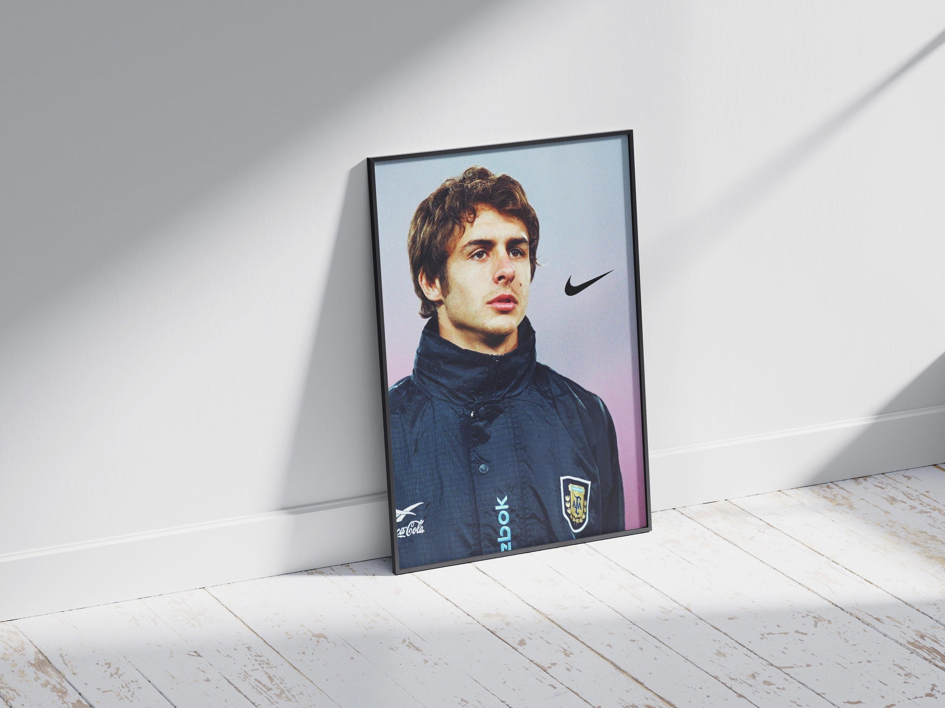 The Pablo Aimar Portrait Poster by Retro1999 shows a young man in a dark sports jacket with the Argentina crest, Nike and Zook logos, leaning against a white wall on a sunlit wooden floor, evoking Argentina football history.